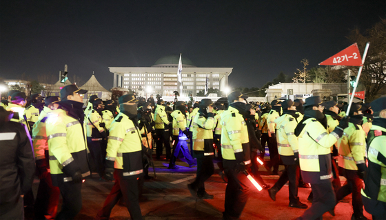 지난해 12월 4일 새벽 윤석열 당시 대통령의 비상계엄 선포 이후 국회 본회의에서 해제 요구 결의안이 통과되자 서울 여의도 국회 정문 앞에 배치됐던 경찰 병력 일부가 이동하고 있다. 전민규 기자