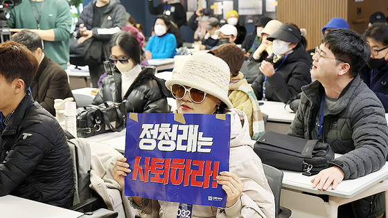 1일 서울 여의도 더불어민주당 중앙당사 당원존에서 열린 '당원 주권 정당 실현을 위한 제도개선 토론회'에 참석한 민주당원이 정청래 대표를 규탄하는 손팻말을 들고 있다. 연합뉴스