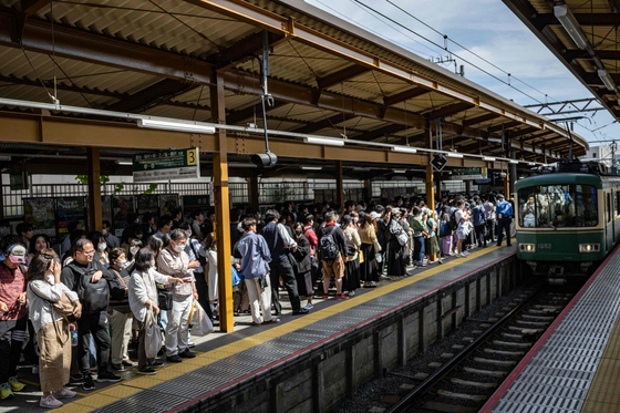 지난 2023년 5월 3일 일본 가나가와현 가마쿠라시의 가마쿠라역에서 사람들이 기차를 기다리고 있다. AFP=연합뉴스