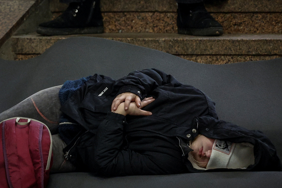 지난달 29일(현지시간) 우크라이나 키이우에서 러시아의 미사일과 드론 공습으로 지하철역 안 방공호에서 잠을 자는 한 우크라이나 어린이. 로이터=연합뉴스