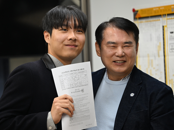 2026학년도 수능 성적표 배부일인 5일 오전 광주 서구 서석고등학교에서 수능 만점자 재학생 최장우군이 이정선 광주시교육감과 기념사진을 찍고 있다. 뉴시스