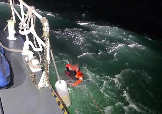 지난 4일 오후6시20분쯤 충남 태안 천리포 해상에서 발생한 어선 전복사고 현장에서 헤경이 바다에 빠진 선원을 구조하고 있다. [사진 태안해경]