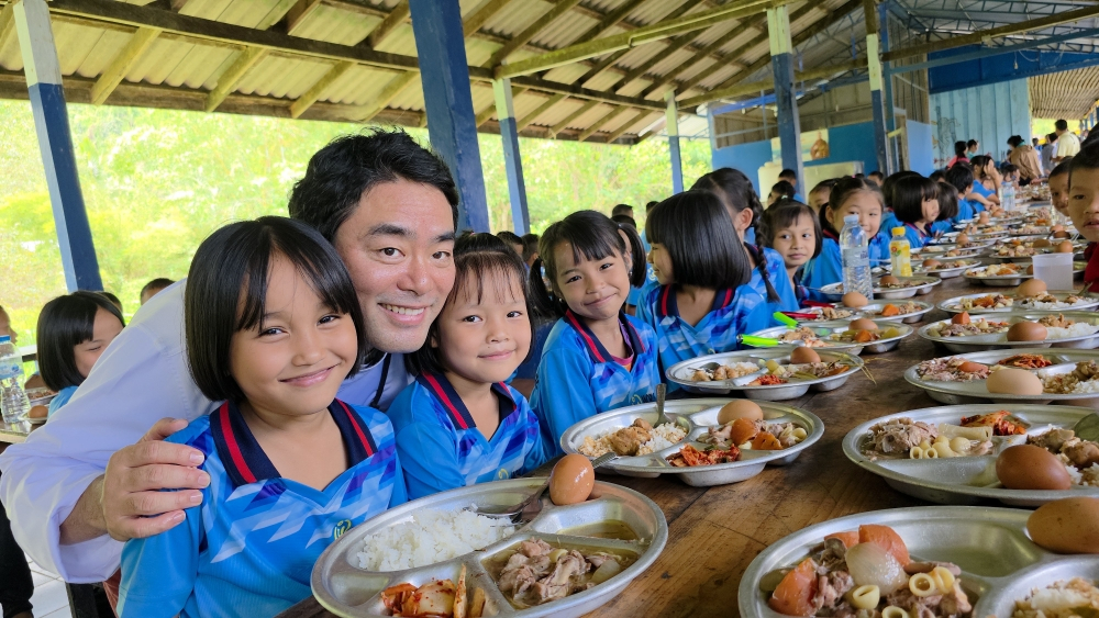 무료급식 행사에서 토미 리 셰프와 파라이녹 학교 아이들이 환하게 웃고 있다. (사진 제공=(사)월드쉐어)