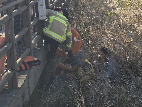 경기 화성동탄경찰서 동탄2지구대 박대희(40·사진 맨 오른쪽) 경장이 공원 연못에 빠진 70대 노인을 구조하고 있다. 사진 독자