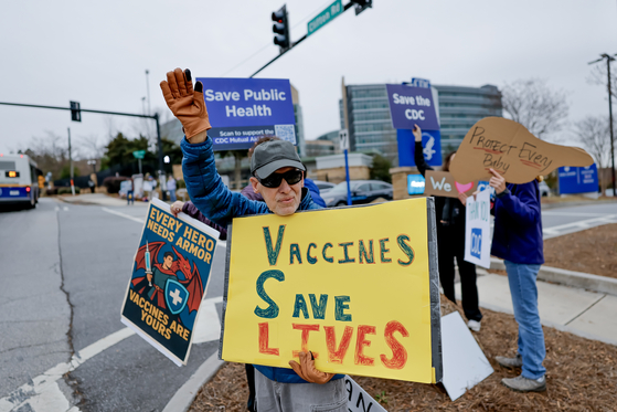 지난 4일 미국 조지아주 애틀랜타에서 열린 미국 질병통제예방센터(CDC) 본부 밖 시위에서 한 사람이 '백신은 생명을 구한다'라고 적힌 팻말을 들고 있다. EAP=연합뉴스