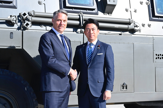 7일 일본을 방문한 리처드 말스 호주 국방장관 겸 부총리가 고이즈미 신지로 방위상과 악수를 나누고 있다. AP=연합뉴스 