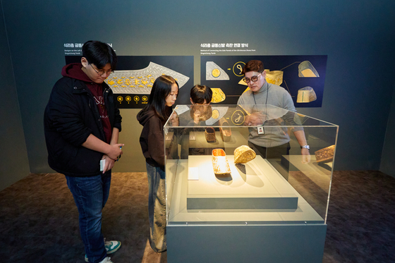 디지털로 복원해 100년 만에 완전한 형태를 갖춘 식리총 금동신발 재현품을 살펴보는 소중 학생기자단.