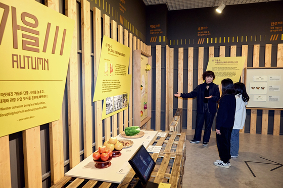 김미정(맨 왼쪽) 학예연구사와 함께 기후변화로 인해 바뀐 과일 생산지 지도를 살펴본 소중 학생기자단. 