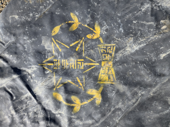 지난 9월부터 이뤄진 부산항 제1부두 발굴 조사에서 확인된 1920년대 천막지. '부두관리 완전무결'이라는 글씨와 군의 것으로 추정된느 마크가 찍혀있다. 사진 부경문물연구원