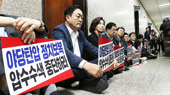 국민의힘 나경원 의원 등이 지난 9월 서울 여의도 국회 원내대표실 앞에서 '야당탄압 정치보복 압수수색 중단하라'라고 적힌 손팻말을 들고 농성을 하고 있다. 연합뉴스