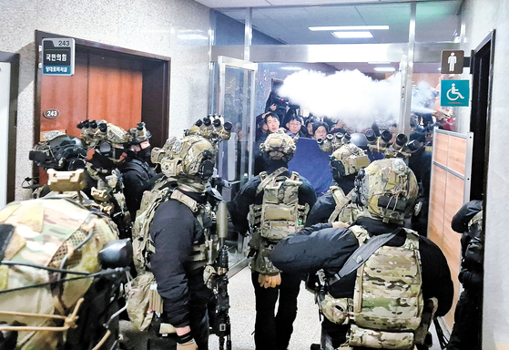 지난해 12월 3일 당시 윤석열 대통령이 비상계엄을 선포한 가운데 4일 밤 서울 국회의사당에서 계엄군이 국회 본청으로 진입하고 있다. 연합뉴스