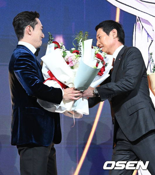 [OSEN=조은정 기자] 9일 오후 서울 송파구 잠실동 롯데호텔 월드에서 2025 신한은행 SOL 뱅크 KBO 골든글러브 시상식이 열렸다.KBO 골든글러브 시상식은 포지션별 최고의 선수를 가리는 자리로 올 시즌의 대미를 장식하는 자리다.2루수 부문을 수상한 LG 신민재가 염경엽 감독에게 꽃다발을 받고 있다. 2025.12.09 /cej@osen.co.kr