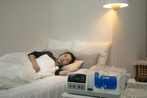 환자가 집에서 자면서 복막투석을 하는 모습을 이미지로 표현했다(사진 속 인물은 모델임). 배꼽 근처 구멍으로 관을 연결하고 거기로 투석액을 주입해 노폐물을 걸러낸다.(사진 속 인물은 모델임) 사진제공 밴티브