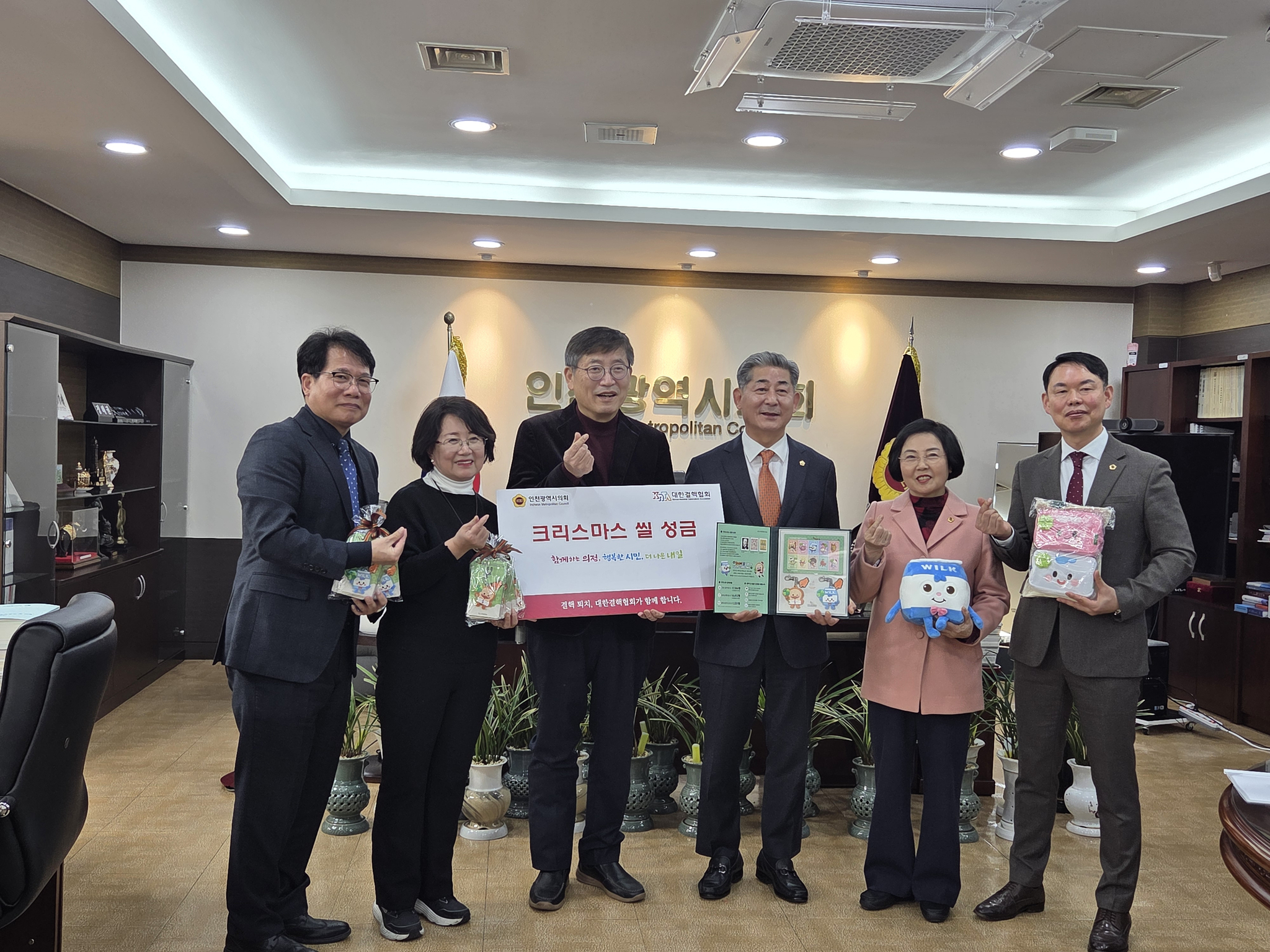 우윤식 대한결핵협회 인천지회장(왼쪽 셋째)이 정해권 인천시의회 의장(오른쪽 셋째)에게 크리스마스 씰을 전달한 뒤 관계자들과 기념사진을 찍고 있다.