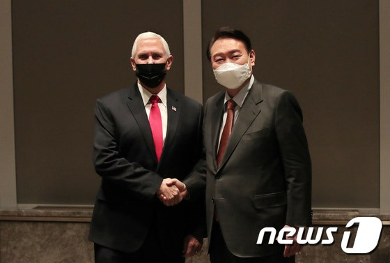 2022년 2월 통일교 한반도 평화 서밋 행사서 만나 악수를 나누는 윤석열 전 대통령과 마이크 펜스 전 미 부통령. 뉴스1