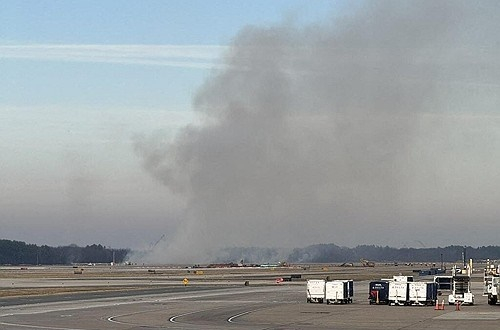 13일(현지시간) 미국 버지니아주 소재 워싱턴 덜레스 국제공항의 활주로 근처에서 항공기 비상착륙에 따른 화재로 연기가 피어오르고 있다. AFP=연합뉴스