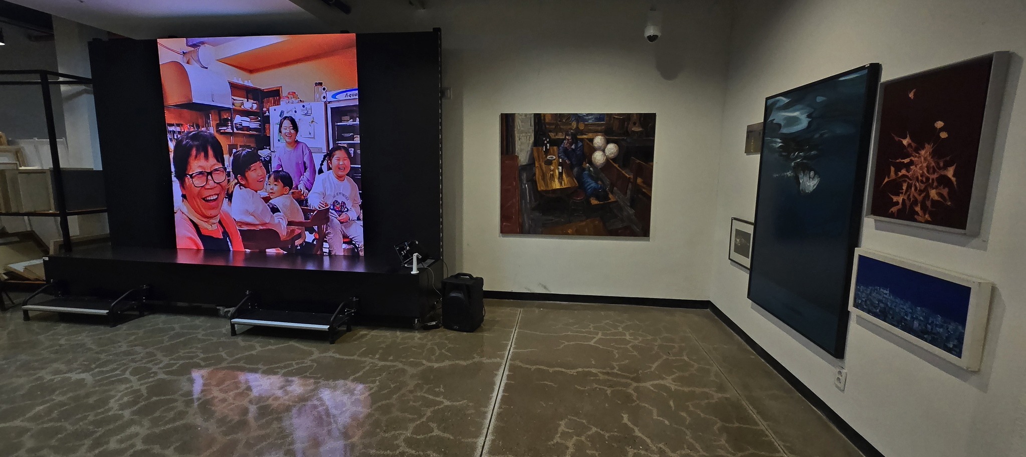 '은자전' 전시장 모니터에서 '새벽강' 주인 강은자(왼쪽)씨가 가게에 온 작가 등과 함께 찍은 사진이 나오고 있다. 김준희 기자