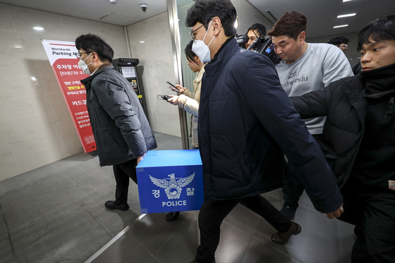 경찰이 대규모 개인정보 유출 사태를 빚은 쿠팡을 상대로 강제수사에 나선 9일 오후 서울 송파구 쿠팡 본사 사무실에서 압수수색을 마친 경찰들이 압수품을 옮기고 있다. 뉴스1