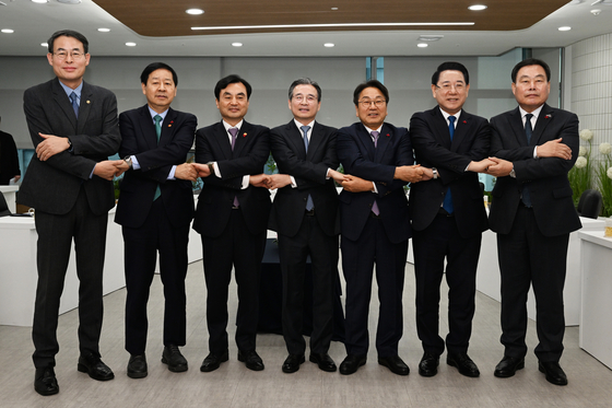 17일 오전 광주 서구 광주도시공사에서 열린 '광주 군 공항 이전 6자 협의체' 1차 회의에서 참석 내빈들이 공동 발표문에 서명한 뒤 손을 맞잡고 있다. 연합뉴스