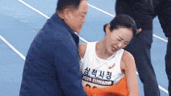 지난달 23일 인천국제마라톤에서 김완기 감독(왼쪽)이 1위로 골인하는 이수민 선수를 잡아주는 장면. 그러나 '부적절한 신체접촉' 논란이 일었다. 사진 유튜브 캡처