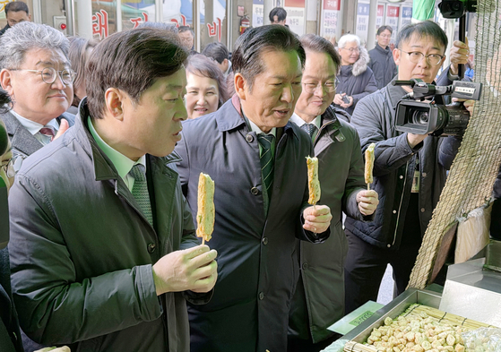 정청래 더불어민주당 대표가 17일 허영 의원과 함께 강원 춘천 온의동 풍물시장을 방문해 어묵을 맛보고 있다. 뉴스1