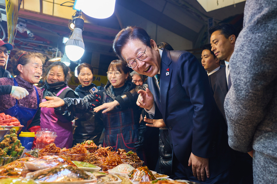 이재명 대통령이 23일 해양수산부 청사에서 국무회의를 마친 뒤 부산 부산진구 부전시장을 찾아 상인들과 이야기를 나누고 있다. 사진 대통령실