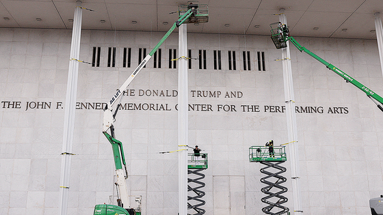 워싱턴의 존 F. 케네디 공연예술센터 외벽에 도널드 트럼프 미국 대통령의 이름을 새긴 글자판이 추가된 모습. 센터 이사회가 기관명을 '도널드 J. 트럼프와 존 F. 케네디 기념 공연예술센터'로 변경한다고 발표한 다음 날인 19일, 작업자들이 리프트 위에 서 있다. 로이터=연합뉴스
