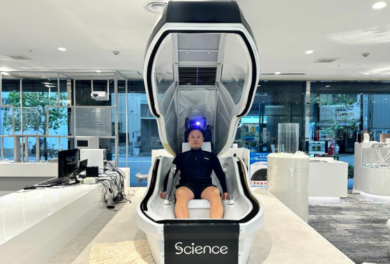 인간 세탁기에서 목욕 체험을 하는 중인 슈칸분슌의 기자. 사진 슈칸분슌