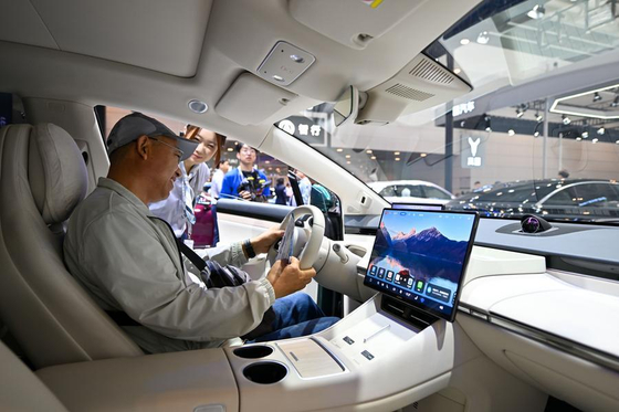 9월 30일 '2025 중국(톈진·天津)국제모터쇼'에서 관람객이 스마트 주행 기능을 갖춘 자동차를 살펴보고 있다. 신화통신