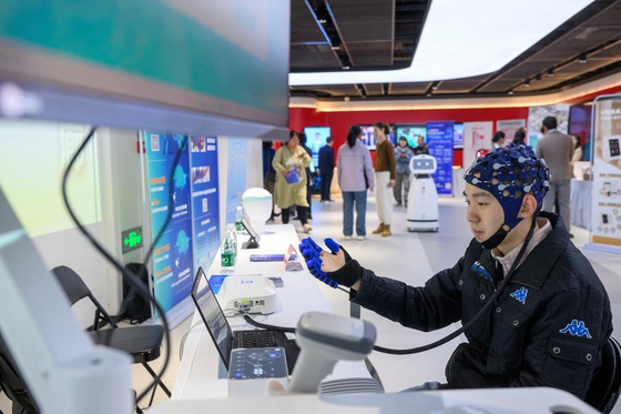 10월 25일 '경로의 달' 테마 행사에서 뇌-기계 인터페이스(BMI) 손 재활 운동 시스템을 시연하는 엔지니어. 신화통신