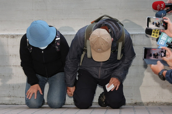 대만 타이베이 지하철 흉기 난동 사건의 용의자 부모가 23일 타이베이시 법의검시부검센터에서 취재진 앞에 무릎을 꿇고 사과하고 있다. AFP=연합뉴스