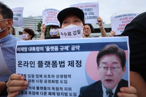 온라인플랫폼법 제정 촉구 공동행동 회원들이 지난 9월 1일 서울 용산구 대통령실 앞에서 열린 온라인플랫폼법 제정 촉구 기자회견에서 이재명 대통령에게 공약 이행을 촉구하는 메시지기 적힌 팻말을 들고 있다.연합뉴스