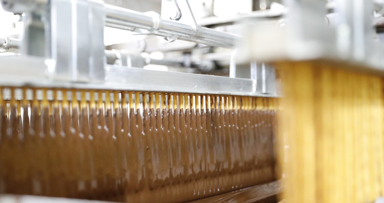 스틱 과자에 액상 초콜릿이 코팅되고 있다. [사진 롯데웰푸드]