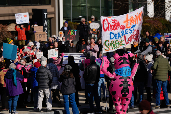  20일(현지시간) 미국 워싱턴에서 도널드 트럼프 전 대통령이 임명한 이사회가 존 F. 케네디 메모리얼 공연예술센터 명칭에 트럼프 대통령의 이름을 추가하기로 의결한 가운데, 인근에서 시위대가 이에 항의하고 있다. AP=연합뉴스