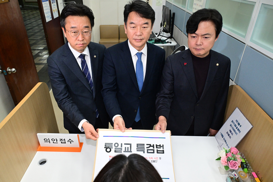 문진석 더불어민주당 원내수석(가운데)이 26일 서울 여의도 국회 의안과에 통일교 특검법안을 제출하고 있다. 뉴스1