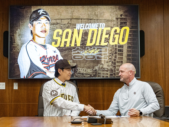 계약서에 서명하고 샌디에이고 관계자와 악수하는 송성문(왼쪽). 사진 키움 히어로즈