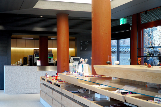 미니멀한 카페 공간과 단차를 활용해 시야에 개방감을 준 진열대. 전통 한옥의 재료인 목재를 사용해 궁궐의 고즈넉함을 표현했다. 사진 국가유산진흥원