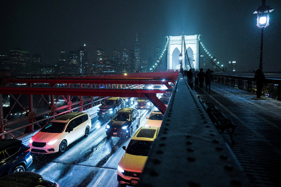  26일(현지시간) 미국 뉴욕에서 겨울 폭풍 속에 차량들이 브루클린 브리지를 지나고 있다. 로이터=연합뉴스