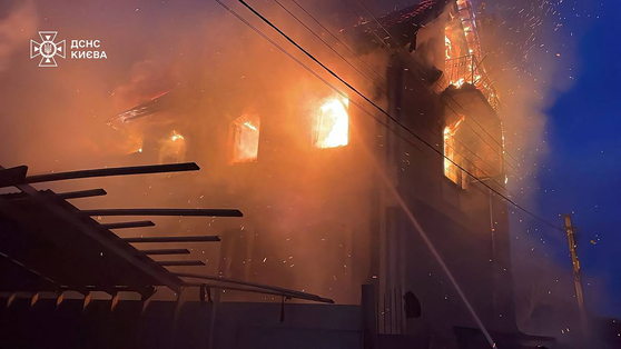 27일(현지시간) 러시아의 공습을 받은 우크라이나 수도 키이우의 한 건물에서 화염이 솟아오르고 있다. AFP=연합뉴스