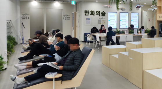 지난 22일 부산 연제구에 있는 연제만도서관 열람공간 '만화의숲'에서 방문객이 만화책을 보고 있다. 사진 부산 연제구