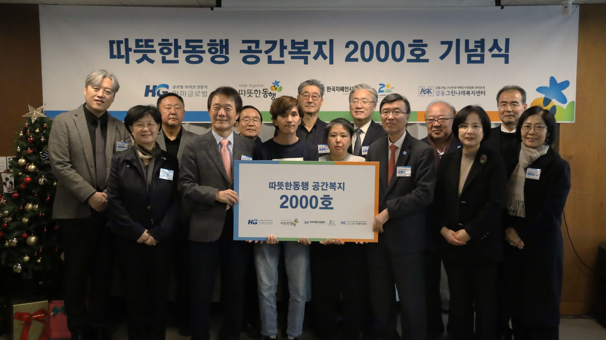 따뜻한동행 공간복지 2,000호 기념식: 따뜻한동행 김종훈 이사장, 송필호 신임 이사장, 김용직 이사, 양옥경 이사, 정연성 감사, 이광재 상임대표를 비롯한 관계자들이 수혜기관 이용자들과 함께 기념촬영을 하고 있다.