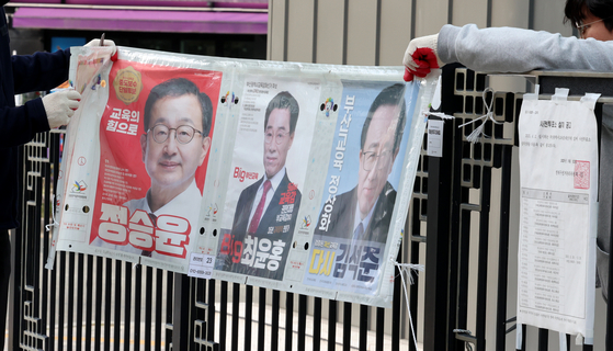 지난 4월 부산 연제구에서 부산시선거관리위원회 관계자들이 부산시교육감 재선거 벽보를 철거하고 있다. 연합뉴스