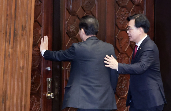 김병기 전 더불어민주당 원내대표가 30일 오후 송언석 국민의힘 원내대표와 대화하면서 본회의장을 나가고 있다. 김성룡 기자