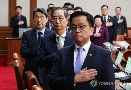 한덕수 대통령 권한대행 국무총리가 1일 정부서울청사에서 열린 국무회의에서 국기에 경례를 하고 있다. 오른쪽부터 최상목 부총리 겸 기획재정부 장관, 한 권한대행, 이주호 부총리 겸 교육부 장관. [대통령실통신사진기자단] 