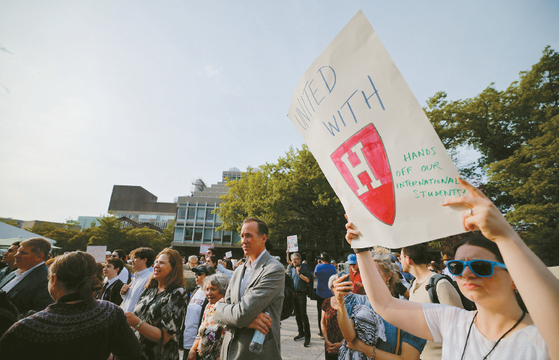 매사추세츠주 케임브리지에 위치한 하버드대학교에서 지난 27일 유학생들을 지지하기 위해 열린 '하버드 스탠드 유나이티드(Harvard Stand United)' 집회에서 한 사람이 피켓을 들고 있다. [로이터]