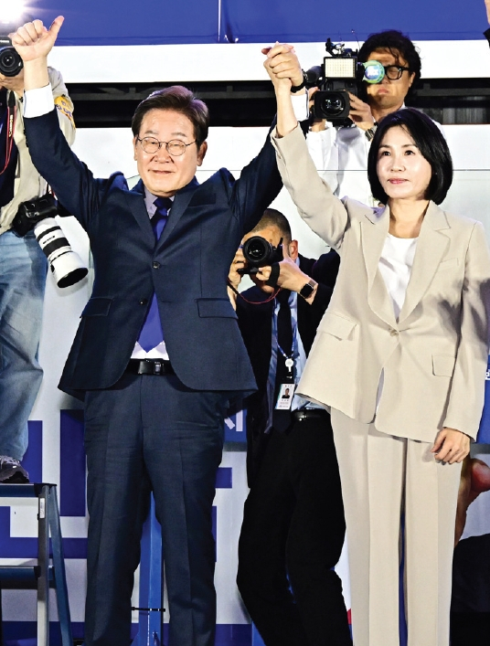 이재명 제21대 대한민국 대통령 당선인(왼쪽)이 부인 김혜경 여사와 함께 4일 서울 여의도 국회 인근에서 더불어민주당 주최로 열린 국민개표방송에 참석, 시민들을 향해 인사하고 있다.  [연합뉴스]
