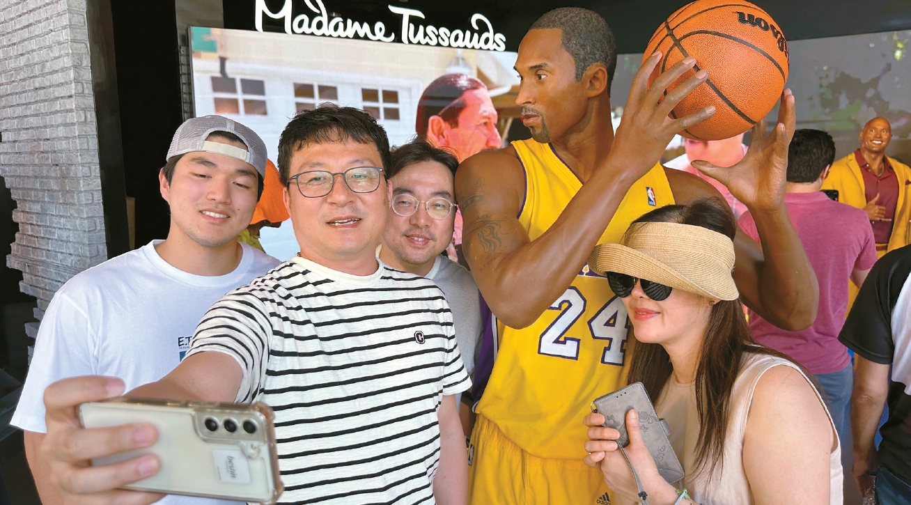 18일 할리우드 마담 투소 밀랍인형 박물관을 찾은 한국인 관광객들이 전설의 농구 스타 코비 브라이언트 인형 앞에서 기념촬영을 하고 있다.  김상진 기자