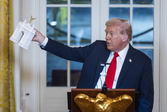 도널드 트럼프 미국 대통령이 지난해 10월 15일 미국 워싱턴 백악관에서 열린 연회장 확장 공사를 위한 기금 모금 만찬에서 워싱턴에 설치하기로 한 개선문 모형을 들고 연설하고 있다. EPA=연합뉴스