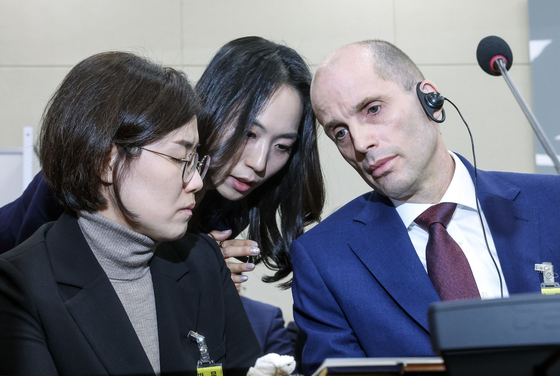 지난해 12월 30일 국회에서 열린 '쿠팡 침해사고 및 개인정보 유출, 불공정 거래, 노동환경 실태 파악과 재발방지 대책 마련을 위한 청문회'에 출석한 해롤드 로저스 쿠팡 임시대표가 관계자와 대화하고 있다. 김성룡 기자