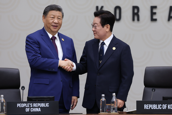 이재명 대통령(오른쪽)이 지난해 11월 1일 경주화백컨벤션센터(HICO)에서 열린 2025 아시아태평양경제협력체(APEC) 정상회의 의장국 인계식에서 2026 APEC 의장국인 중국의 시진핑 국가주석에게 의장직 지위를 넘기며 악수하고 있다. 연합뉴스